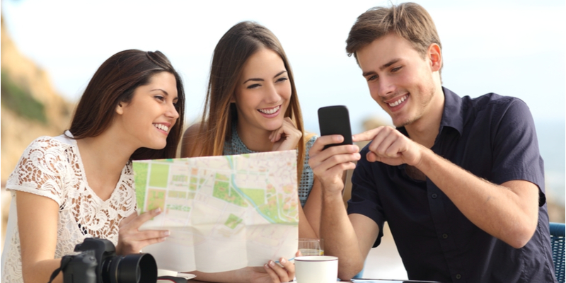 Ragazzi in viaggio controllano un app sullo smartphone